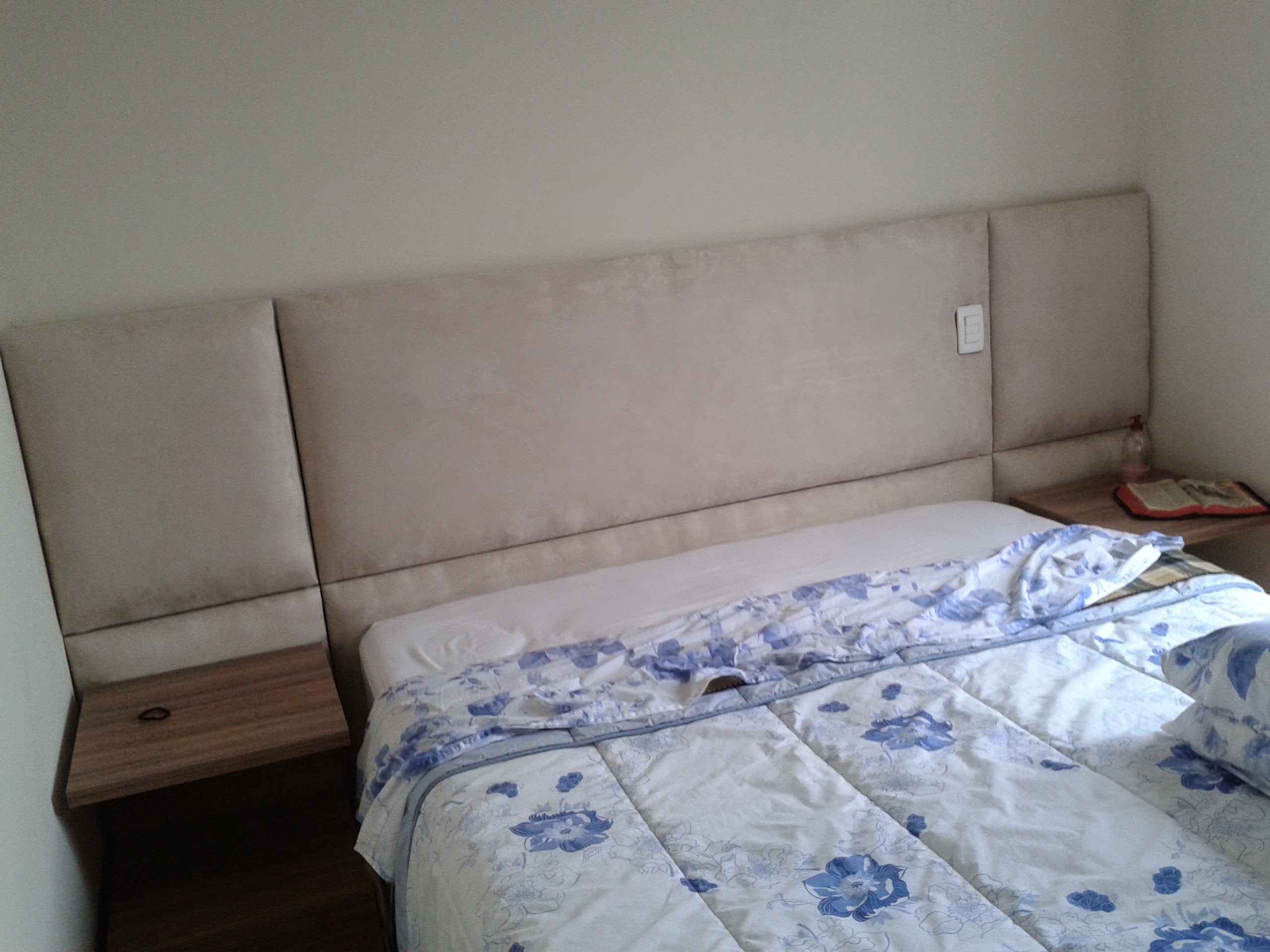 Cabeceira de cama estofada em tecido claro, feita sob medida