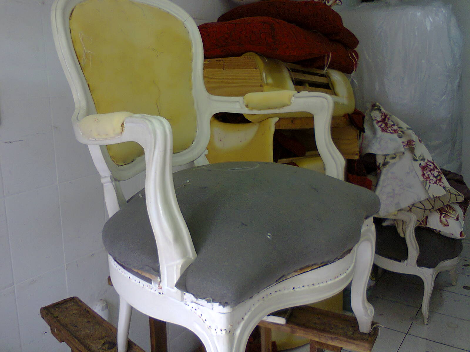 Estrutura de cadeira antiga sendo preparada para receber novo estofado