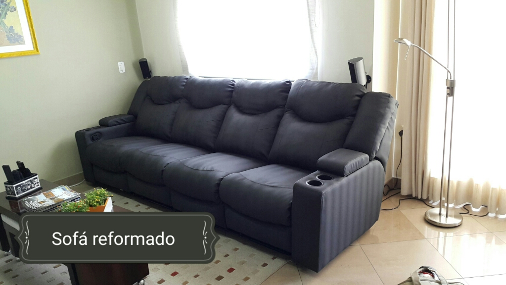 Sofá retrátil de couro preto reformado em sala de estar